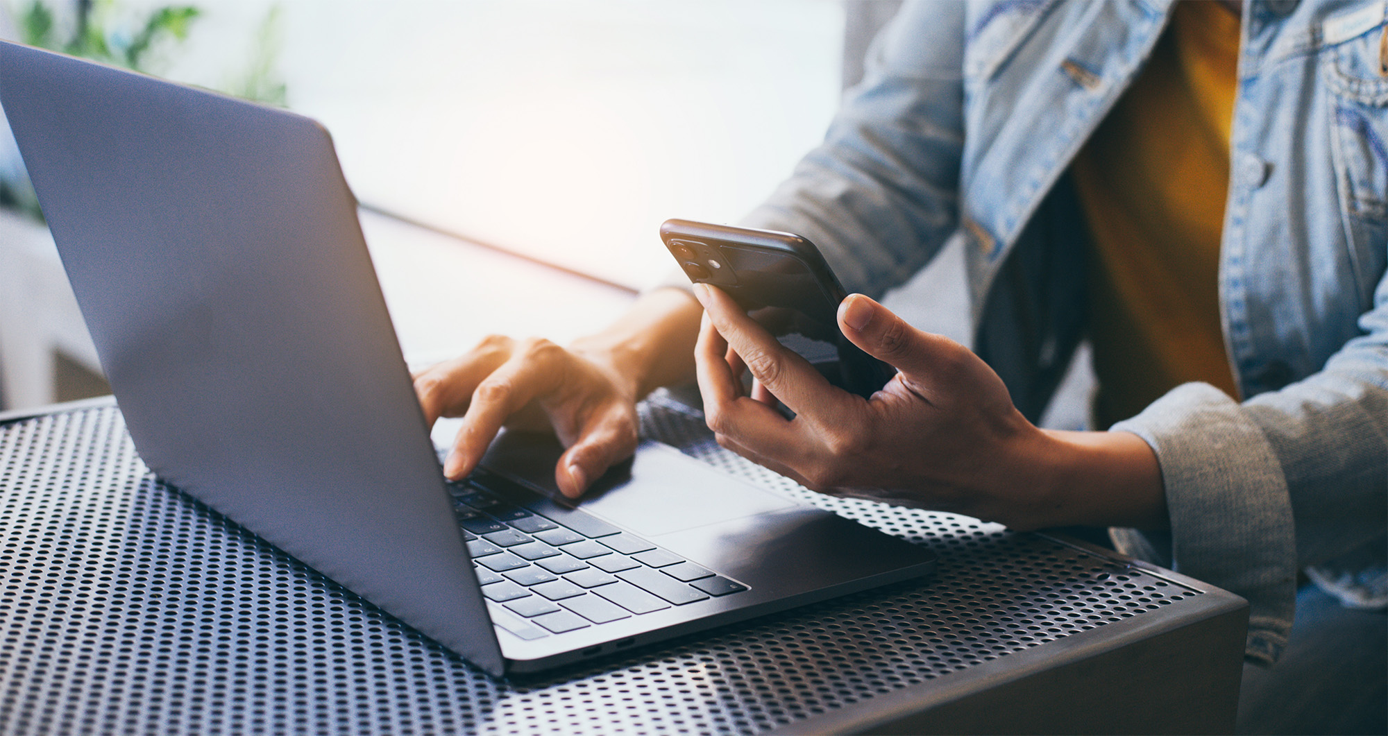 contact-us Person with laptop and mobile phone in hand